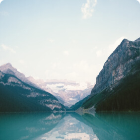 Lago azul com reflexo de montanhas.